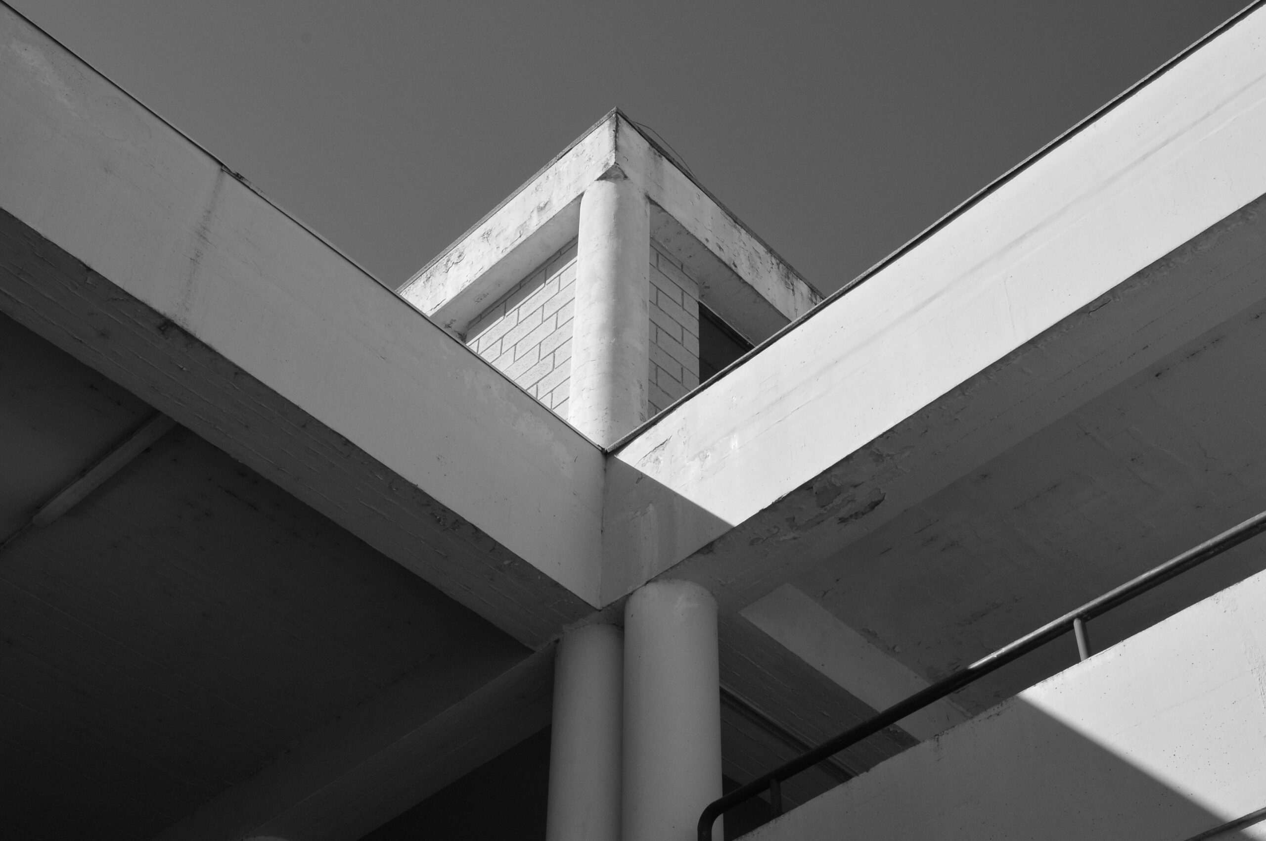 Minimalist black and white photo of a geometric architectural structure with concrete elements.